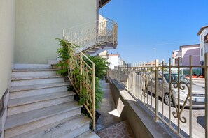 Un escalier avec une rampe en métal, menant à un balcon.