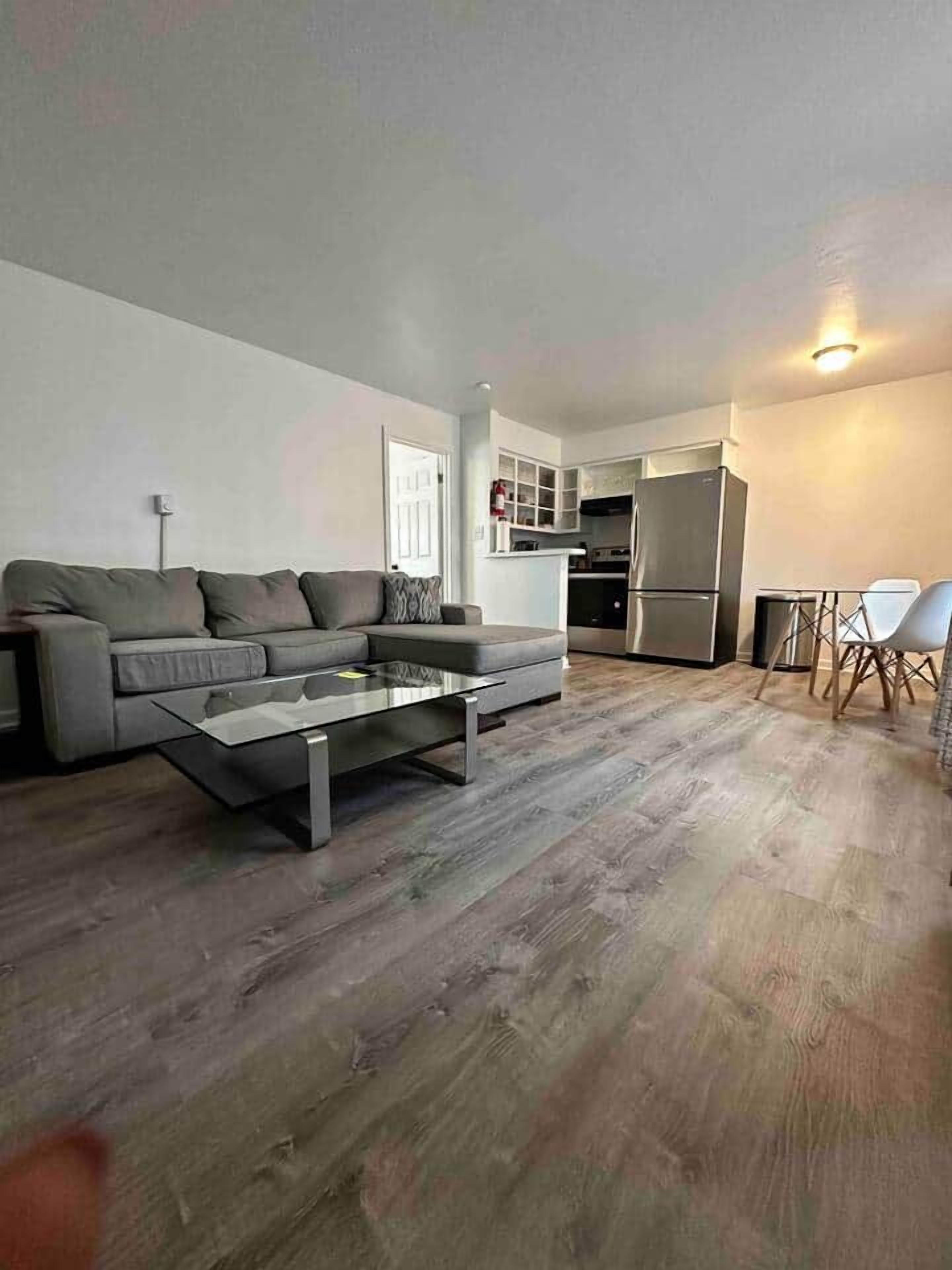 Un salon moderne avec un canapé, une table basse et un coin repas.