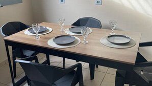A dining area with a rectangular table, four chairs, and a light-colored wall.