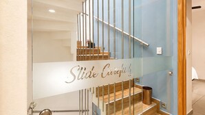 Una escalera moderna con barandillas de vidrio y escalones de madera.