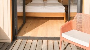 Ein Schlafzimmer mit einem Bett, einem Sessel und einem Bild an der Wand.