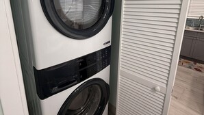 A compact, white, wall-mounted washer and dryer unit with a control panel and a circular door. - Golden Hour: - BRAND NEW 2026 - sunsets, beach, and park in perfect proximity. (Spanish Wells)