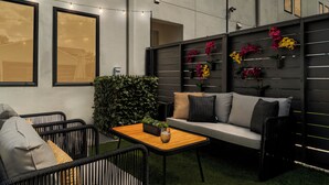 An outdoor seating area with a sofa, chairs, a table, and string lights. - Luxe Modern Artsy TH in Tampa Heights/Next to Downtown/Everything You Need (Tampa)
