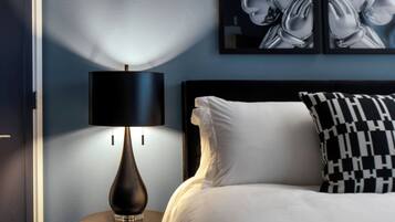 Une chambre à coucher avec un lit, une lampe de chevet, un tableau accroché au mur et une table de chevet.