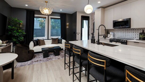 A modern kitchen with a central island, bar stools, a dining table, and a large window. - Luxe Modern Artsy TH in Tampa Heights/Next to Downtown/Everything You Need (Tampa)