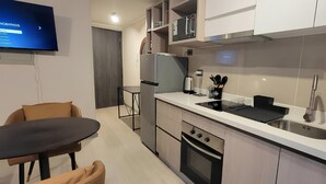 Eine moderne Küche mit eingebautem Ofen, einer Spüle und einem Essbereich mit Tisch und Stühlen.