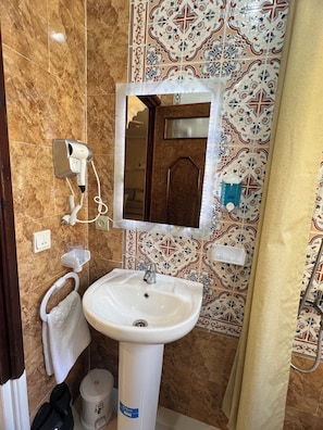 Regadera, secadora de cabello, toallas, papel de baño 