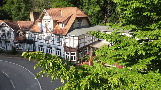 En traditionell byggnad med korsvirkesfasad, och en skylt som visar att det är ett hotell och en restaurang.