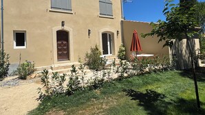 Ein zweistöckiges Gebäude mit einer beigen Fassade, Rundbögen und einem roten Schirm.