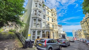 A street with parked cars, a building with bay windows, and a clear sky. - stylish ground floor apartment off Douglas promenade (Douglas)