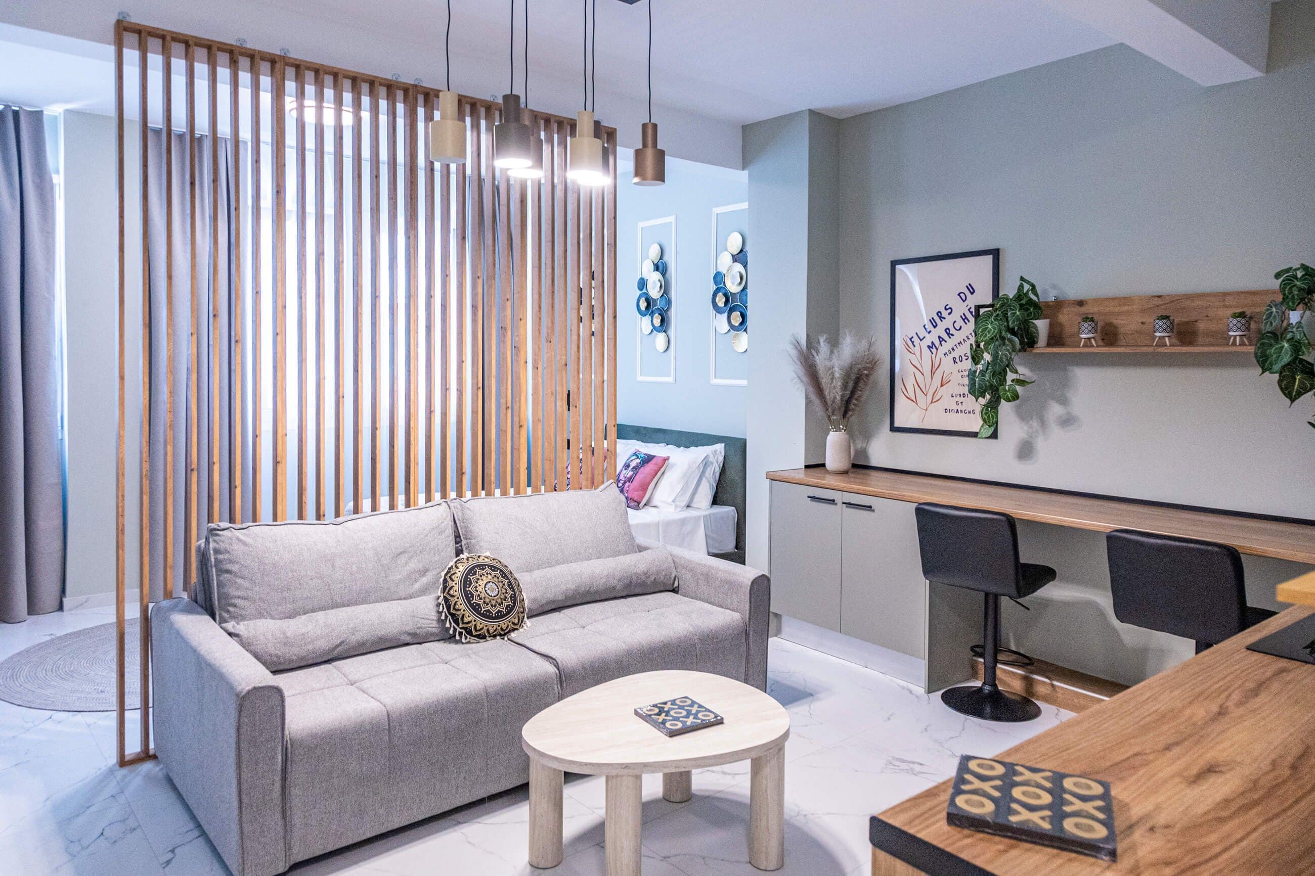 A modern living room with a sofa, a coffee table, and a dining area with chairs and a wooden table.