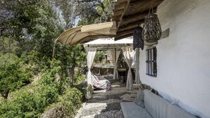 A covered outdoor seating area with a stone pathway leading to a building.