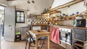 A rustic kitchen with wooden furniture, a built-in oven, and a tiled backsplash.