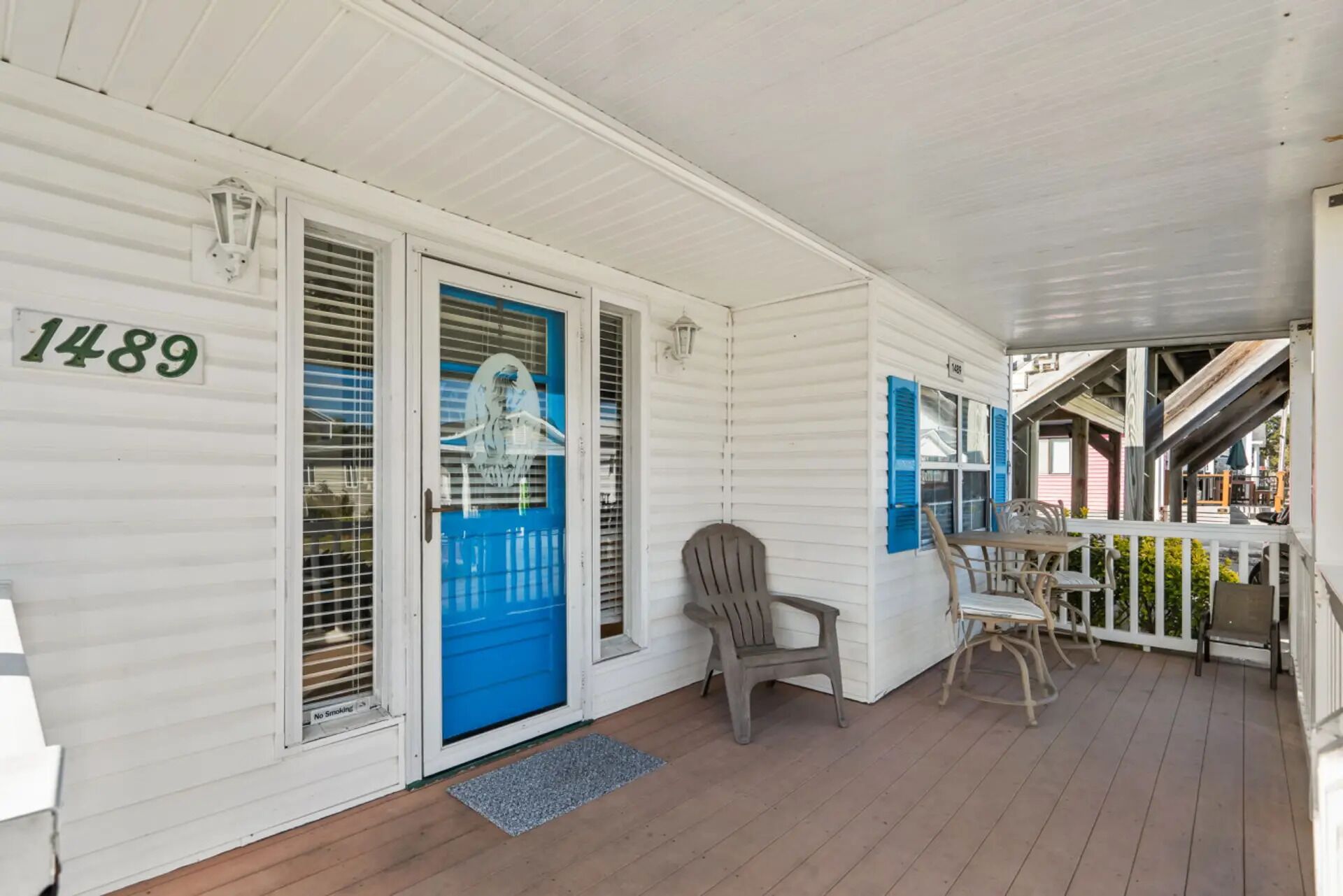 A white building with a blue door and a number '1489' on the wall.