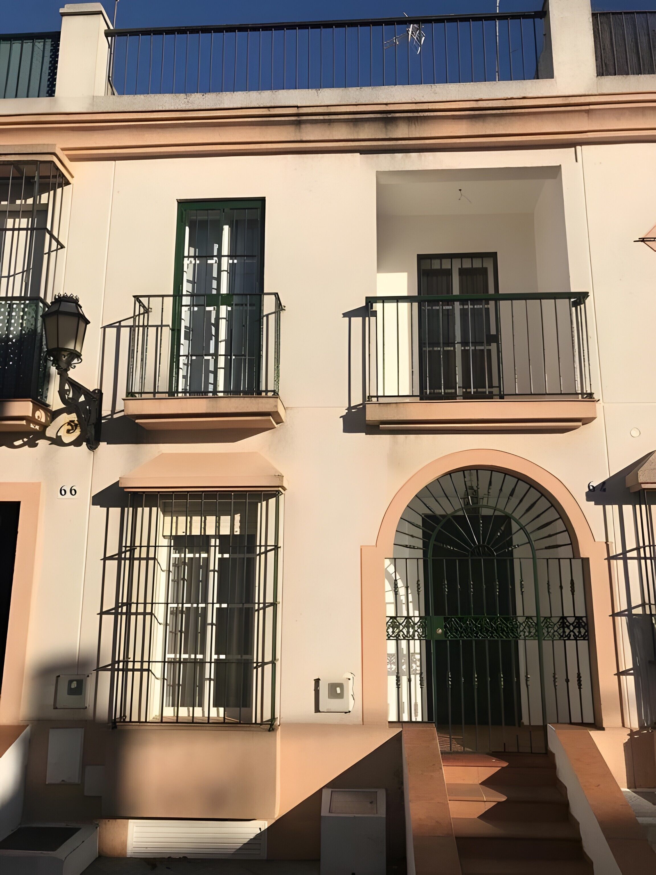 Um edifício com várias varandas, uma grande entrada em arco e uma escadaria que leva à entrada.