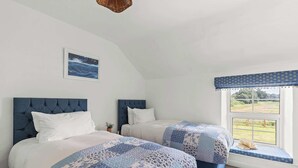 A bedroom with two beds, a window with a view, and a wall-mounted picture. - Pet-Friendly Cottage w/ Garden Near Malton (Malton)