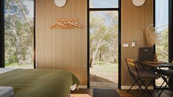 Una habitación con cama, escritorio y vista al exterior.