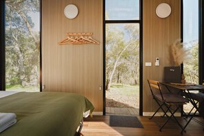 Una habitación con cama, escritorio y vista al exterior.