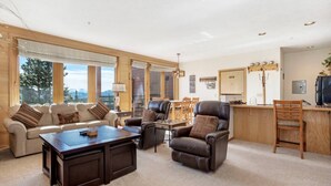 A spacious living room with a sofa, armchairs, a coffee table, and a dining area with a table and chairs. - The Buffalo Lodge | Hot Tub • Stunning Mtn Views! (Silverthorne)