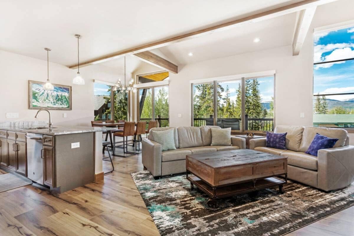 Un amplio espacio de sala con un sofá grande, una mesa de centro y una isla de cocina.