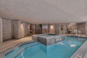 An indoor swimming pool with a hot tub, tiled walls, and a lifeguard sign. - The Lakeside • Ideal Location • Hot Tub • Sleeps 6 (Dillon)