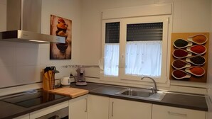 Een moderne keuken met een ingebouwde oven, een spoelbak en een raam met gordijnen.