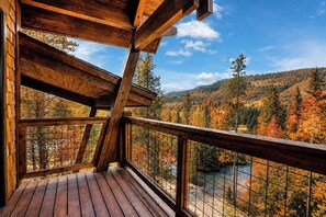 Una terraza de madera con vistas a un valle boscoso.