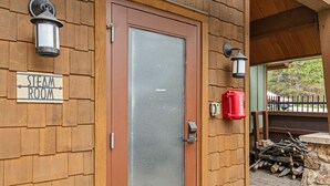 Un edificio in legno con un cartello che riporta 'STEAM ROOM' e una porta con un vetro.