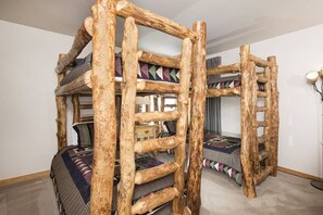 A room with a unique wooden structure, possibly a bunk bed or loft, with a patterned blanket. - Slopeside | Hot Tub • Garage • Pool • Ski Locker! (Keystone)
