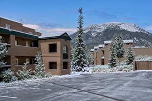 Hotel amb muntanyes de fons, que disposa d'un aparcament i arbres coberts de neu.