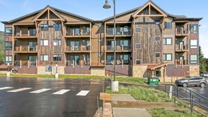 Un immeuble à plusieurs étages doté de balcons, d’un parking et d’un lampadaire.