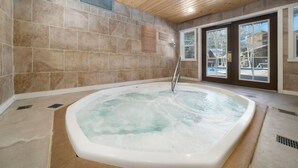 A hot tub in a room with stone walls and a wooden ceiling. - The Wild Irishman | Hot Tub • Free Shuttle • Pool (Dillon)