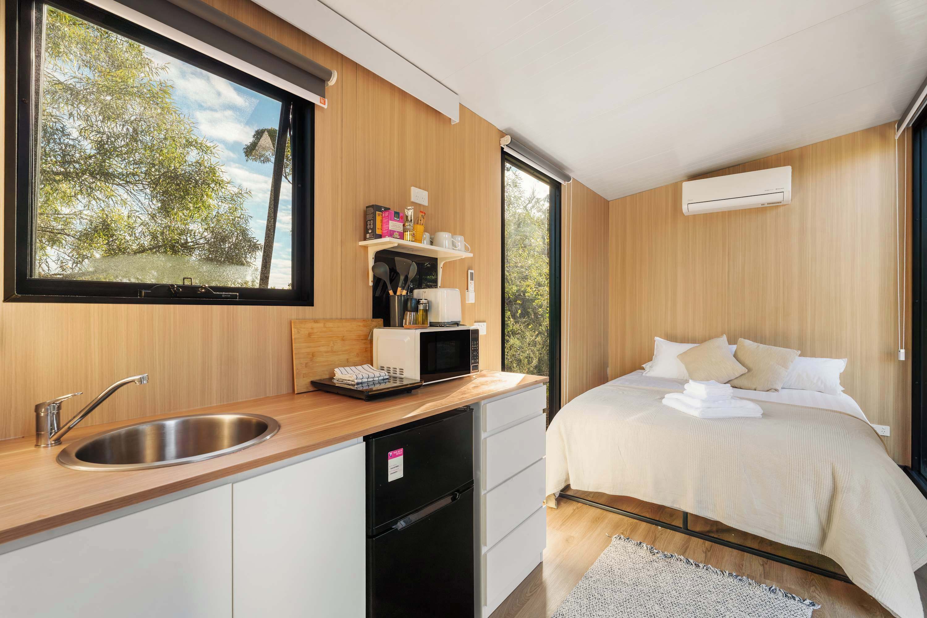 A modern bedroom with a bed, a bedside table, and a window.