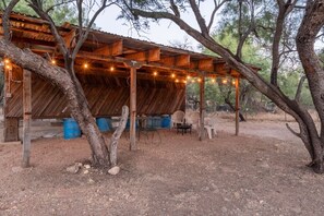 A rustic wooden structure with a covered patio area, outdoor seating, and string lights. - 1945 Ranch House / Tanque Verde / 2 BR 1 BA (Tucson)