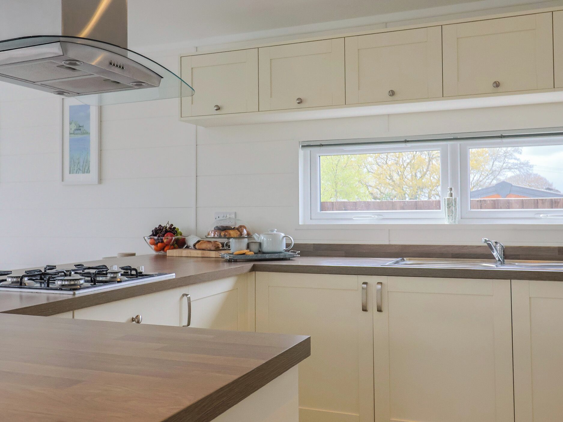 Una cocina con estufa a gas, una ventana y un lavamanos.