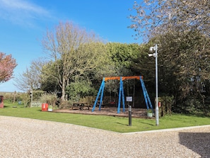 A playground with swings and a picnic table. - Hazelwood 3 (Axminster)