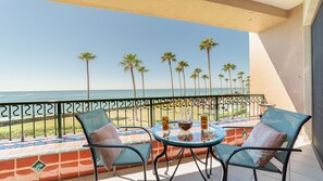 A balcony with two chairs, a table, and a view of the ocean. - Enjoy This Beautiful 2br/2ba Condo by the Beach at the Sonoran Spa Resort (Puerto Peñasco)