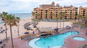 Un resort con amplia zona de piscina, acceso a la playa y vistas al océano.
