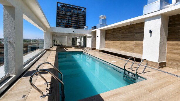 A rooftop pool with clear views of a modern building. - Rbk Nvo Estudio pasos del Movistar arena (Santiago)