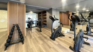 A gym with exercise equipment, wooden flooring, and a mirrored wall. - Rbk Nvo Estudio pasos del Movistar arena (Santiago)