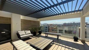 A rooftop terrace with a pergola, seating area, and a city view. - Rbk Nvo Estudio pasos del Movistar arena (Santiago)