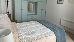 A bedroom with a bed, a wardrobe, a mirror, and a radiator. - Central location, Its our home away from home unique, cosy and charming. (Boat of Garten)