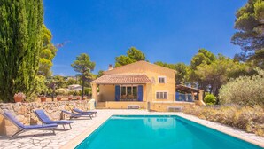 A poolside area with lounge chairs, a pool, and a building with a tiled roof. - Mas Goya, a peaceful villa on the gentle slopes below the pretty hill-top village of Tourtour. (Tourtour)