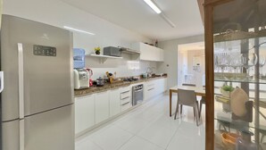 Eine moderne Küche mit Kühlschrank, Kaffeemaschine und Wasserspender.