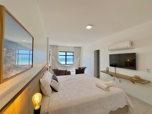 A hotel room with a bed, a TV, a hammock, and a large window with a view. - Al Mare Residencial (Fortaleza)