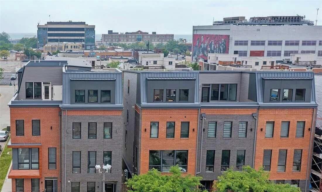 A multi-story building with a modern architectural design, featuring a mix of brick and metal facades, large windows, and a flat roof.