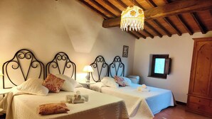 A room with two beds, a wooden ceiling, a small table with a lamp, and a television. - Bellavista (Lastra a Signa)