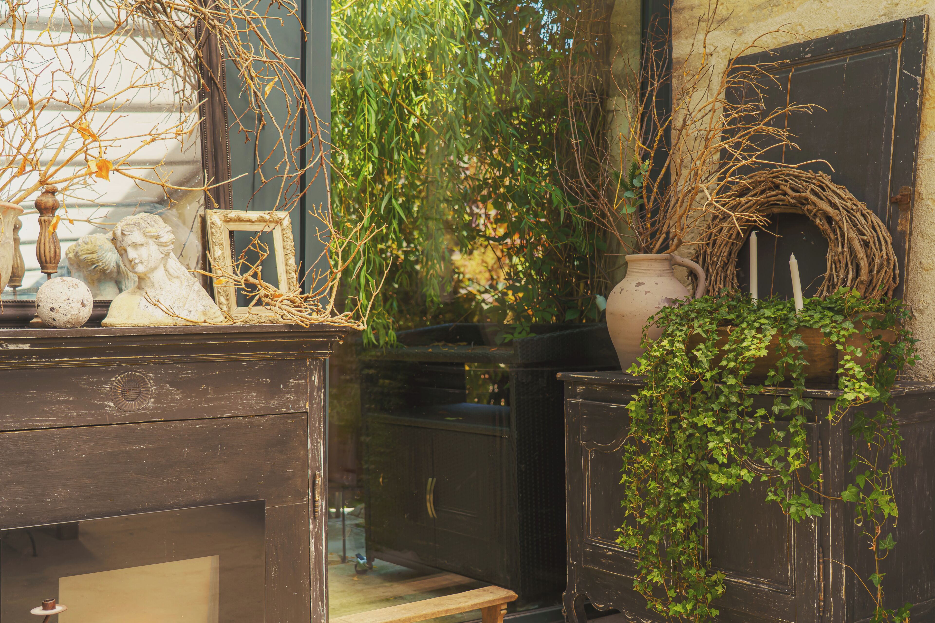 Antique furniture, a vase, and a wreath with candles.