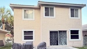 Una casa de dos pisos con un patio.