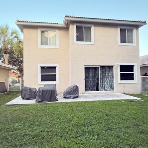 A two-story house with a patio area. - Delightful 2-bedroom house with AC in Coconut Creek (Coconut Creek)